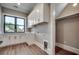 Well-lit laundry room with ample cabinet space, a black window frame and hardwood floors at 2417 Gist Ln., Myrtle Beach, SC 29588