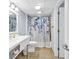 Bright bathroom with blue-patterned shower curtain, tiled floors, and a white vanity at 2501 South Ocean Blvd. # 1011, Myrtle Beach, SC 29577