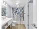Bright bathroom with blue-patterned shower curtain, tiled floors, and a white vanity at 2501 South Ocean Blvd. # 1011, Myrtle Beach, SC 29577