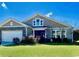 Charming craftsman-style home with stone accents and a well-manicured front lawn on a sunny day at 256 Copper Leaf Dr., Myrtle Beach, SC 29588