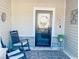 Cozy front porch features rocking chairs, outdoor rug, and stylish decor near the front door at 256 Copper Leaf Dr., Myrtle Beach, SC 29588