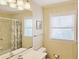 This bright bathroom features a vanity sink, tile floors, shower curtain, and a window with natural light at 312 Norris Dr., Pawleys Island, SC 29585
