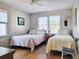 Bright bedroom with two twin beds, white walls, and a window for natural light and a light-toned hardwood floor at 312 Norris Dr., Pawleys Island, SC 29585