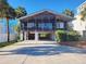 Charming stilt house with screened porch, palm trees, and covered parking underneath at 312 Norris Dr., Pawleys Island, SC 29585