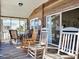 Inviting covered porch with rocking chairs, table, and views of the neighborhood and outdoor living at 312 Norris Dr., Pawleys Island, SC 29585