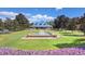 Spacious clubhouse view showcases a well-manicured lawn, a fountain, and colorful flowerbeds in the foreground at 366 Pinehurst Ln. # 13E, Pawleys Island, SC 29585