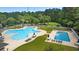 Resort-style community pool with lounge chairs and tables surrounded by lush landscape at 366 Pinehurst Ln. # 13E, Pawleys Island, SC 29585