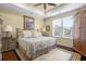 Well-lit bedroom features a ceiling fan, a patterned rug, and a plush bed with decorative pillows at 4228 Ravenwood Dr., Little River, SC 29566