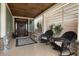 Inviting front porch with outdoor seating and decorative wood ceiling at 4228 Ravenwood Dr., Little River, SC 29566