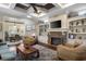 Cozy living room with a stone fireplace, built-in shelves, and a coffered ceiling with a ceiling fan at 4228 Ravenwood Dr., Little River, SC 29566