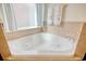 Corner soaking tub featuring tile surround, and beach-themed decor in the bright bathroom at 432 Highfield Loop, Myrtle Beach, SC 29579