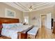 Spacious bedroom with tray ceiling, wood floors, nautical decor, and view into the bathroom at 432 Highfield Loop, Myrtle Beach, SC 29579