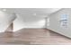 Bright living room features wood-look flooring, stairs to the left, and windows overlooking the neighborhood at 44 Cape Point Dr., Conway, SC 29527