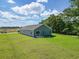 A spacious backyard with lush green lawn and a patio with sliding glass doors at 48 Cape Point Dr., Conway, SC 29527