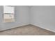 A carpeted bedroom with a window is presented with light gray walls at 48 Cape Point Dr., Conway, SC 29527