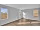A sunlit bedroom features three windows, light gray walls, and wood-look flooring at 48 Cape Point Dr., Conway, SC 29527