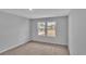 A bedroom with carpet features two windows that overlook the street at 48 Cape Point Dr., Conway, SC 29527