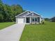 Charming home with gray siding, a well-manicured lawn, and a concrete driveway on a sunny day at 48 Cape Point Dr., Conway, SC 29527