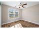 A light-filled bedroom with wood-look floors, a ceiling fan, and a large window for ample natural light at 480 Oakham Dr., Conway, SC 29527