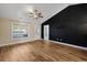 Bright living room showcasing wood floors, a dark accent wall, and a ceiling fan at 480 Oakham Dr., Conway, SC 29527