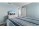 Bright bedroom featuring nautical themed bedspread, dresser with TV, and two entry doorways at 501 S Ocean Blvd. # 1006, North Myrtle Beach, SC 29582