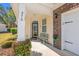 Inviting front porch featuring a cozy bench, stylish lighting, and well-maintained landscaping at 570 Botany Loop Murrells Inlet # 570, Murrells Inlet, SC 29576