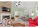Inviting living room with brick fireplace, television, ceiling fan, plantation shutters, and an open layout at 570 Botany Loop Murrells Inlet # 570, Murrells Inlet, SC 29576