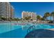 Large community pool with lounge chairs and palm trees surrounding multiple buildings at 5825 Catalina Dr. # 1133, North Myrtle Beach, SC 29582