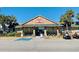 Exterior of recreation center with handicap parking, golf cart, rocking chairs, and tropical trees at 6001 - 1268 S Kings Hwy., Myrtle Beach, SC 29575