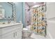 Bright bathroom showcasing a shower with colorful, fish-themed curtain, sink and cabinet at 6004 Flowerdale Ct., Myrtle Beach, SC 29579