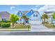 Charming blue two-story home with a well-manicured lawn, palm trees, and a two car garage at 6004 Flowerdale Ct., Myrtle Beach, SC 29579