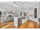 Open kitchen and living area with stainless appliances, white cabinets, and wood flooring at 6004 Flowerdale Ct., Myrtle Beach, SC 29579