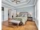 Bright main bedroom features tray ceiling, wooden floors, and neutral decor at 6004 Flowerdale Ct., Myrtle Beach, SC 29579