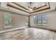 Bedroom showcasing hardwood-style floors, three windows, and tray ceilings at 6013 Blease Ct., Myrtle Beach, SC 29588