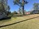 Backyard with storage shed, mature trees and green grass; perfect for outdoor activities at 61 Lakewood Dr., Andrews, SC 29510