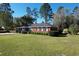 A well-maintained red brick home with a lush green lawn and mature trees in a suburban setting at 61 Lakewood Dr., Andrews, SC 29510