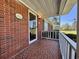 Covered porch with brick flooring and white railing, offering a welcoming entrance to this charming home at 61 Lakewood Dr., Andrews, SC 29510