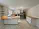 Bright kitchen features tile floors, white cabinetry, light countertops and stainless steel refrigerator at 61 Lakewood Dr., Andrews, SC 29510