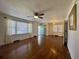 Spacious living room with gleaming hardwood floors, large windows, ceiling fan, and neutral paint throughout at 61 Lakewood Dr., Andrews, SC 29510