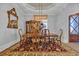 Formal dining room featuring a hardwood table, decorative rug, ornate mirror, and abundant natural light at 6121 Bolsena Place, Myrtle Beach, SC 29572