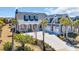 Angle view of gray home with a three-car garage and manicured front lawn at 6121 Bolsena Place, Myrtle Beach, SC 29572
