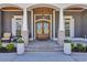 Elegant home entry featuring a gorgeous wooden front door and well-manicured flower pots at 6121 Bolsena Place, Myrtle Beach, SC 29572
