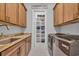 This laundry room boasts ample cabinet space, modern washer and dryer, and tile floors at 6121 Bolsena Place, Myrtle Beach, SC 29572