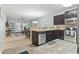Open-concept kitchen with stainless appliances, dark cabinets, breakfast bar, and view into the dining and living areas at 6253 Catalina Dr. # 713, North Myrtle Beach, SC 29582