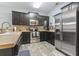 This kitchen features dark cabinets, stainless steel appliances, and stylish backsplash, all on light wood flooring at 6253 Catalina Dr. # 713, North Myrtle Beach, SC 29582