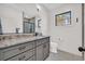 Bathroom features gray cabinets, stone countertops, tile floors and a black framed window at 644 Whispering Pines Ct., Murrells Inlet, SC 29576
