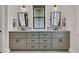 Double sink vanity with black fixtures, gray cabinets, stone countertop, and stylish black-framed mirrors at 644 Whispering Pines Ct., Murrells Inlet, SC 29576