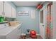 Practical laundry room with washer, dryer, storage cabinets, and colorful accents at 800 9Th Ave. S # T3, North Myrtle Beach, SC 29582