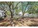 Tree-filled backyard with a charming white picket fence providing privacy and enclosing the outdoor space at 81 Safe Harbor Ave., Pawleys Island, SC 29585