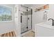 Modern bathroom with a glass shower enclosure, patterned tile, and white vanity at 837 Flicker Pl., Murrells Inlet, SC 29576
